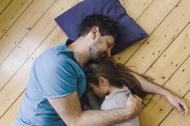 Father and daughter lying together on floor at home - JOSEF17057