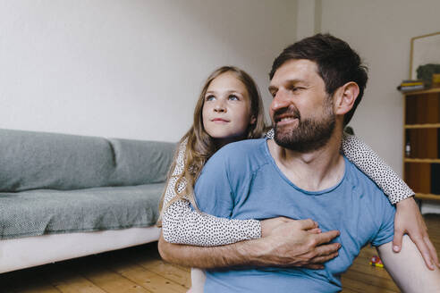 Mädchen umarmt Vater sitzt im Wohnzimmer zu Hause - JOSEF17090