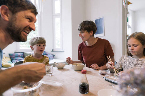 Parents eating food with children on dining table at home - JOSEF17099