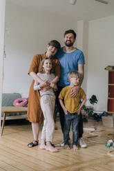 Glückliche Familie, die im Wohnzimmer zu Hause zusammensteht - JOSEF17120