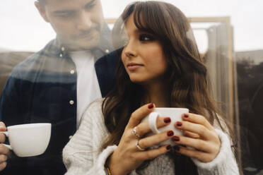 Paar hält Kaffeetassen im Kuppelzelt - JJF00098
