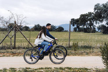 Ehepaar fährt Fahrrad auf unbefestigtem Weg - JJF00115