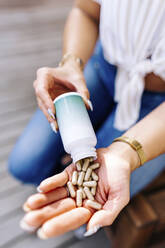 Hands of woman holding capsule pills - JJF00136