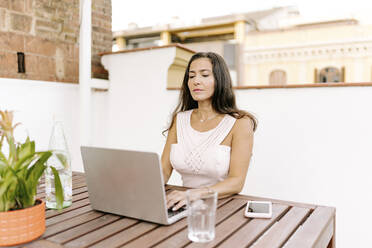 Freiberufler arbeitet am Laptop am Tisch - JJF00165