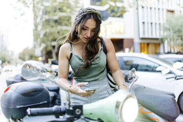 Woman renting electric scooter on road - JJF00206