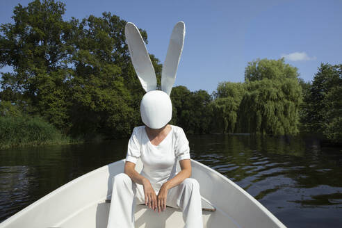 Frau mit Kaninchenmaske sitzt im Boot - PSTF01024