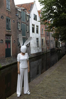 Frau mit Kaninchenmaske auf dem Fußweg stehend - PSTF01033