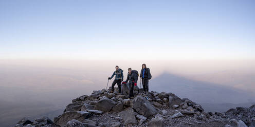Freunde stehen auf einem Berg vor dem Himmel bei Sonnenuntergang - ALRF02001
