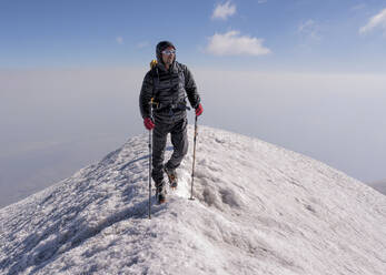 Mann beim Wandern auf einem verschneiten Berg am Wochenende - ALRF02004