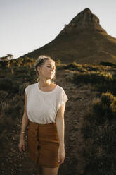 Frau genießt das Sonnenlicht vor dem Lion's Head Mountain bei Sonnenuntergang - LHPF01476