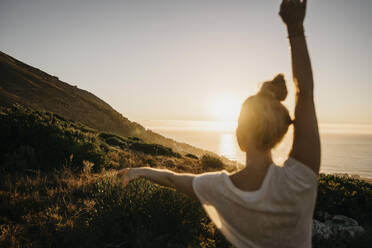 Young woman dancing in front of clear sky at sunset - LHPF01477