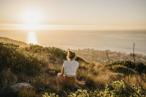 Woman admiring sea sitting on Signal Hill at weekend - LHPF01480