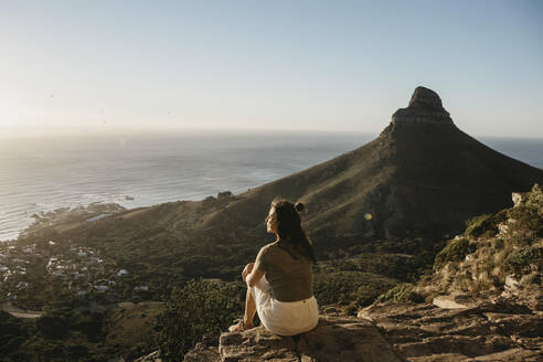 Frau bewundert das Meer am Lion's Head Mountain bei Sonnenuntergang - LHPF01485