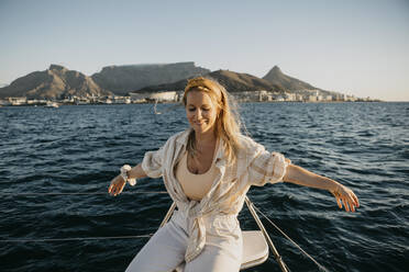 Glückliche Frau genießt am Wochenende auf einem Boot auf dem Meer - LHPF01495
