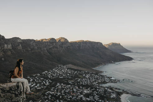 Frau schaut am Wochenende vom Lion's Head Mountain auf das Meer - LHPF01504