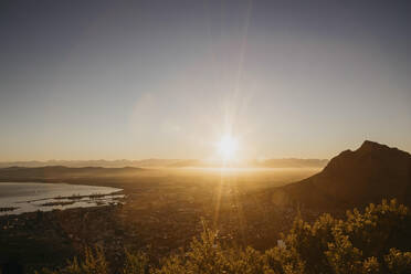 Scenic view of mountain and sea in front of clear sky at sunrise - LHPF01505