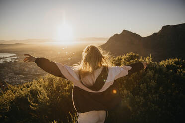 Woman with arms outstretched at sunrise - LHPF01506