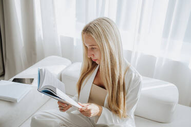 Young psychologist reading book in clinic - MDOF00613