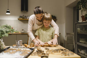 Mutter und Sohn beim Backen von Ingwerkeksen in der Küche zu Hause - VBUF00256