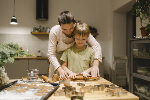 Mutter und Sohn beim Backen von Ingwerkeksen in der Küche zu Hause - VBUF00256