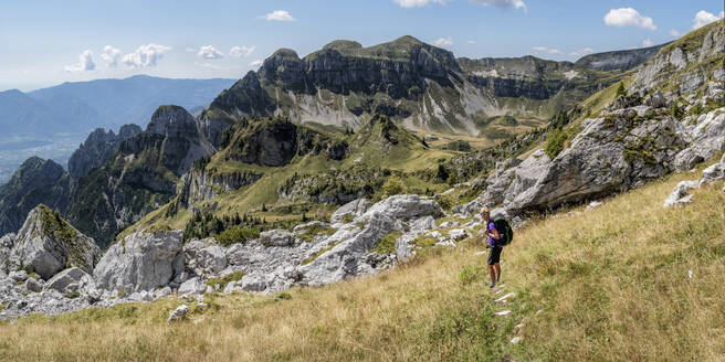 Ältere Frau mit Rucksack vor einem Berg in den Dolomiten, Italien - ALRF02013