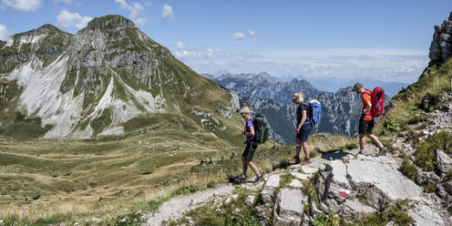 Mann und Frau mit Rucksack wandern zum Rifugio dal piaz an einem sonnigen Tag in den Dolomiten, Italien - ALRF02018