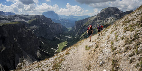 Frau und Mann wandern an einem sonnigen Tag in den Dolomiten zum Rifugio Puez, Italien - ALRF02040