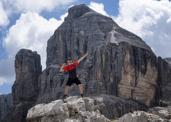 Man with arm raised standing at Cima Pisciadu, Dolomites, Italy - ALRF02049