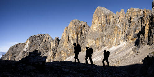 Silhouette friends hiking on sunny day at Pala di San Martino mountain, Dolomites, Italy - ALRF02080