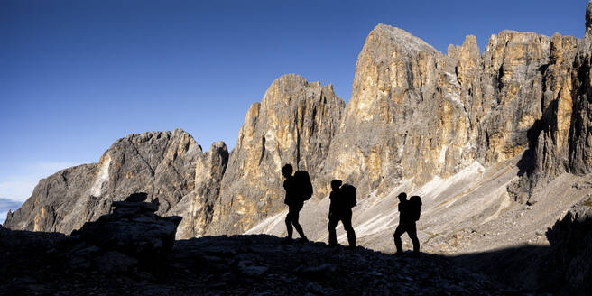 Silhouette Freunde wandern an einem sonnigen Tag auf dem Berg Pala di San Martino, Dolomiten, Italien - ALRF02080