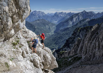 Pärchen beim Klettern an einem sonnigen Tag im Nationalpark Dolomiti Bellunesi, Forcella Comedon, Dolomiten, Italien - ALRF02085