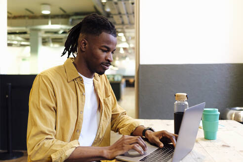 Businessman working on laptop at office - ASGF03290