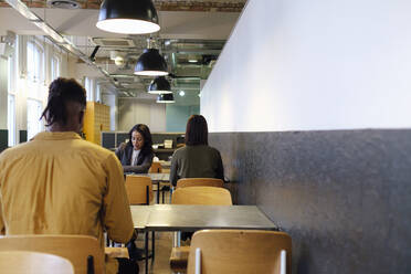 Business colleagues working together in cafeteria at office - ASGF03299