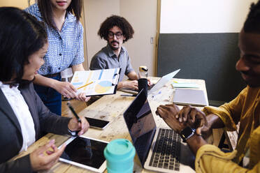 Businesswoman planning strategy with colleagues in meeting at office - ASGF03347