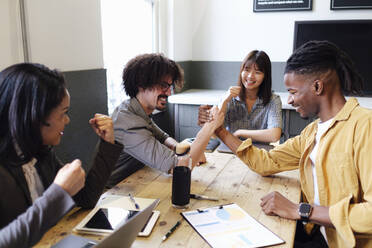 Businesswomen cheering colleagues doing arm wrestling at office - ASGF03376