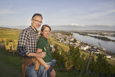 Happy couple having fun with wineglasses in vineyard - RORF03356