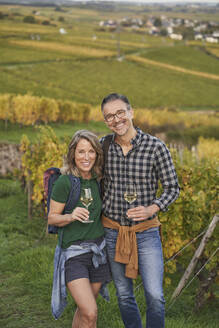Glückliches reifes Paar bei einer Weinprobe im Weinberg - RORF03382