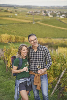 Nachdenkliches Paar mit Weingläsern auf einem Hügel stehend - RORF03384