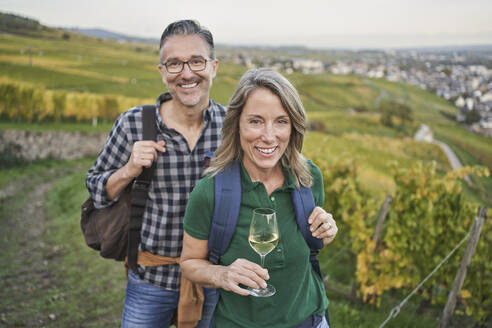 Glückliches reifes Paar bei einer Weinprobe im Weinberg - RORF03395