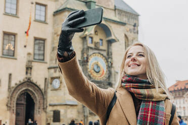 Happy woman taking selfie through smart phone on vacation - VSNF00441