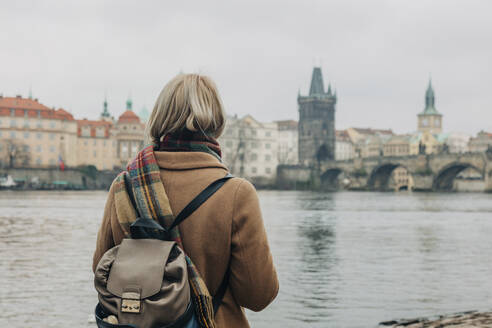 Frau mit Rucksack steht in der Nähe des Flusses - VSNF00445