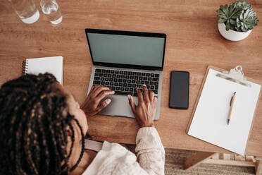 Freelancer working on laptop at desk - EBBF07980