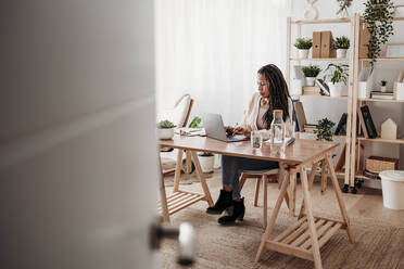 Businesswoman using laptop at desk in home office - EBBF07984