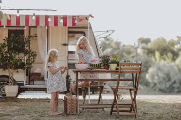 Schwestern genießen ein Picknick vor einem Wohnmobil - MDOF00627