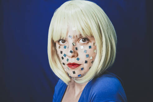 Woman with small mirrors on face against colored background - SVCF00312