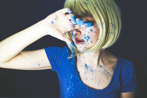 Woman covered with blue powder paint against black background - SVCF00332