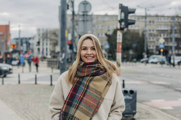 Lächelnde Frau in warmer Kleidung auf der Straße - VSNF00501