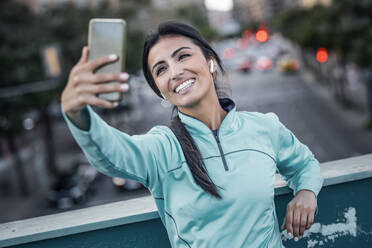 Glückliche junge Frau nimmt Selfie durch Mobiltelefon - JSRF02374