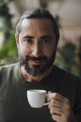 Smiling bearded man holding coffee cup - JOSEF17165