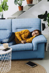 Woman relaxing on sofa at home - JJF00240